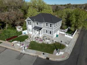 View of front facade featuring a garage, roof with shingles, driveway, and stone siding