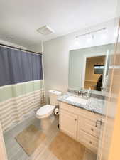 Full bathroom with vanity, a shower with shower curtain, and a textured ceiling