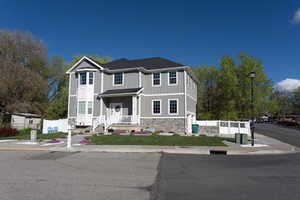 View of front of house with stone siding, an attached garage, board and batten siding, and a porch