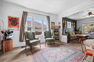 Living area with a ceiling fan and light wood finished floors