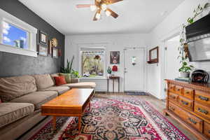 Living area featuring ceiling fan and light wood-type flooring