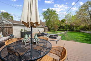 Wooden terrace featuring a fenced backyard and outdoor dining space