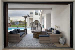 View of patio featuring an outdoor living space with a fire pit and an outdoor pool