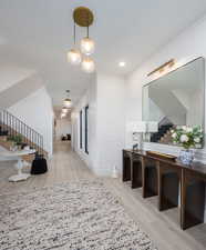 Hallway featuring light wood finished floors, recessed lighting, and a decorative wall