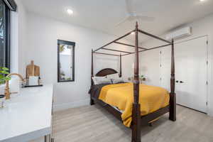 Bedroom with light wood-type flooring, ceiling fan, and recessed lighting