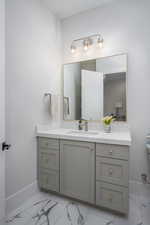 Bathroom with vanity and light marble finish floors