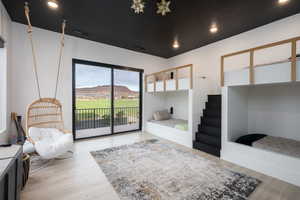 Bedroom featuring access to outside, light wood-style flooring, and recessed lighting