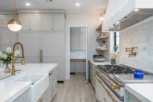 Kitchen featuring extractor fan, gas cooktop, gray cabinets, light wood finished floors, and open shelves