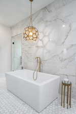 Bathroom featuring a soaking tub and tile walls