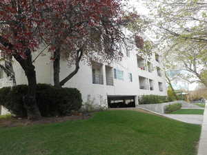 View of side of property with a yard and stucco siding