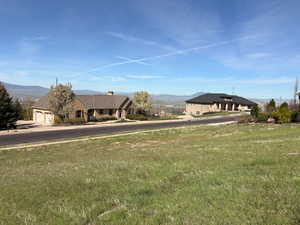 View of front of house with a front lawn and a mountain view