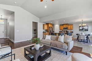 Living area with a chandelier, a ceiling fan, light wood-type flooring, and lofted ceiling