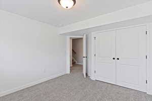 Unfurnished bedroom with light carpet and a closet