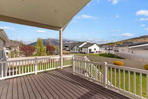 Wooden deck featuring a fenced backyard, a mountain view, and a residential view