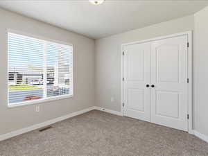 Unfurnished bedroom with carpet and a closet
