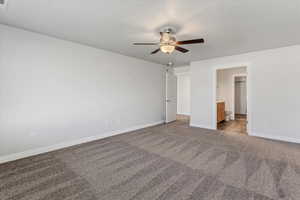 Unfurnished bedroom with ensuite bath, a ceiling fan, carpet floors, and a textured ceiling