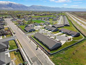 Aerial view of property and surrounding area featuring mountains and nearby suburban area