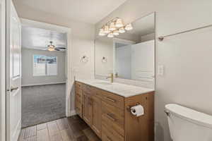 Bathroom featuring vanity, wood tiled floors, and a ceiling fan