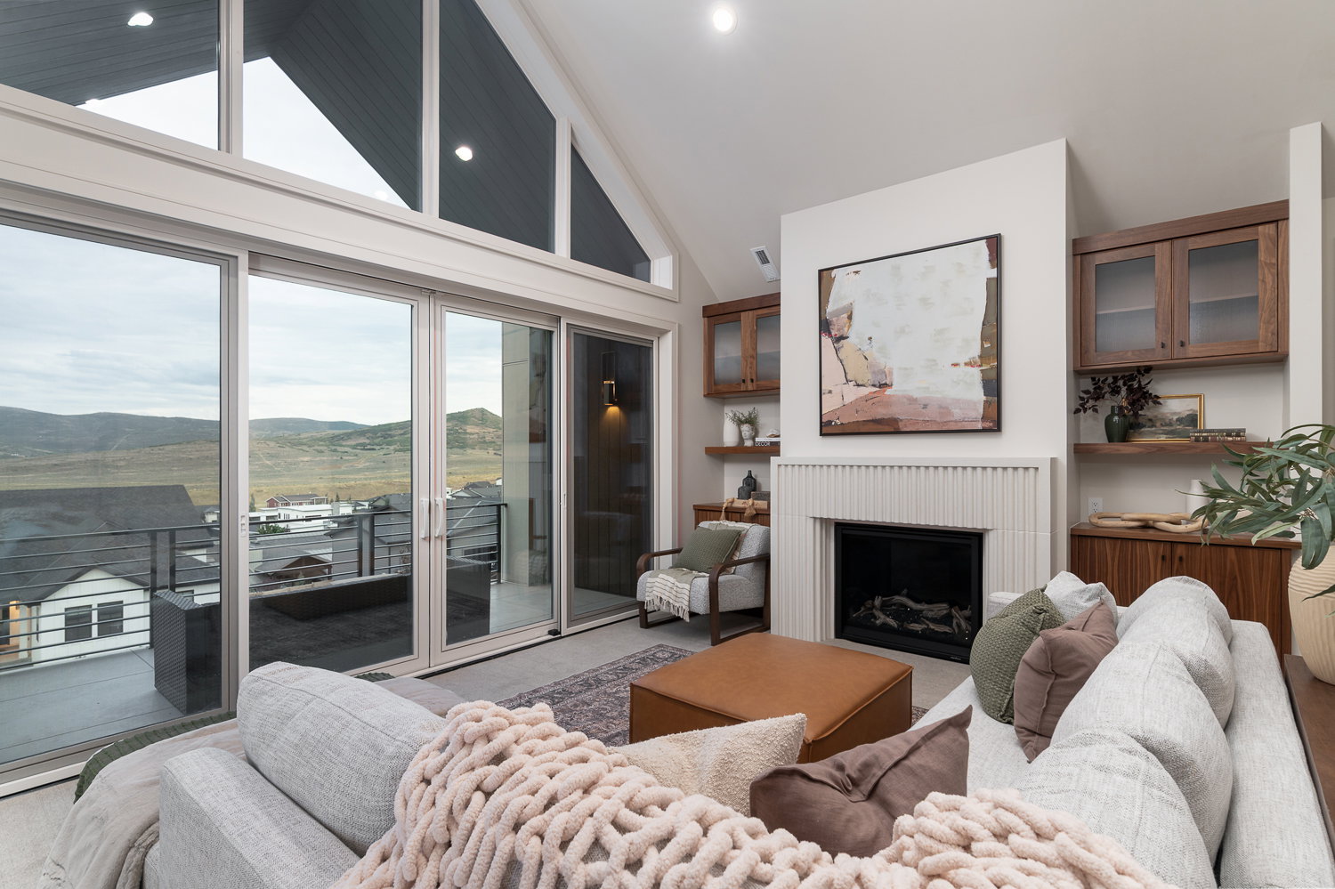 Living area featuring a mountain view, plenty of natural light, a fireplace, and a high ceiling
