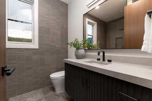Bathroom featuring tile walls and vanity