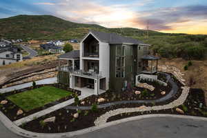 View of front facade featuring a balcony, a patio area, and a mountain view