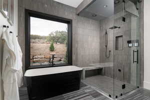 Bathroom with a freestanding bath, a shower stall, and tile patterned flooring