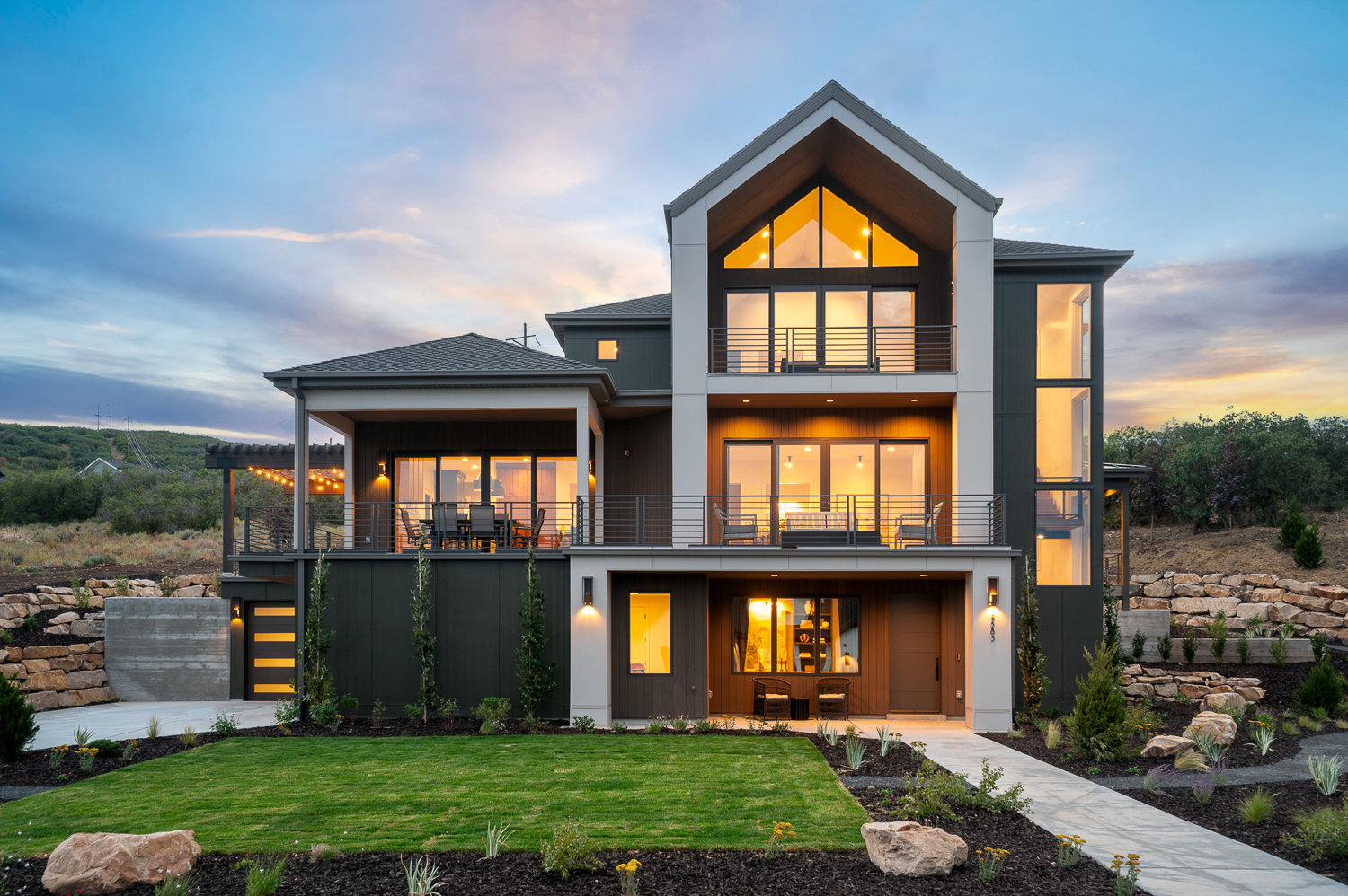 Back of property featuring a balcony, a yard, a shingled roof, and board and batten siding