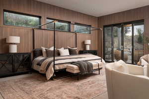 Bedroom with access to exterior and wooden walls
