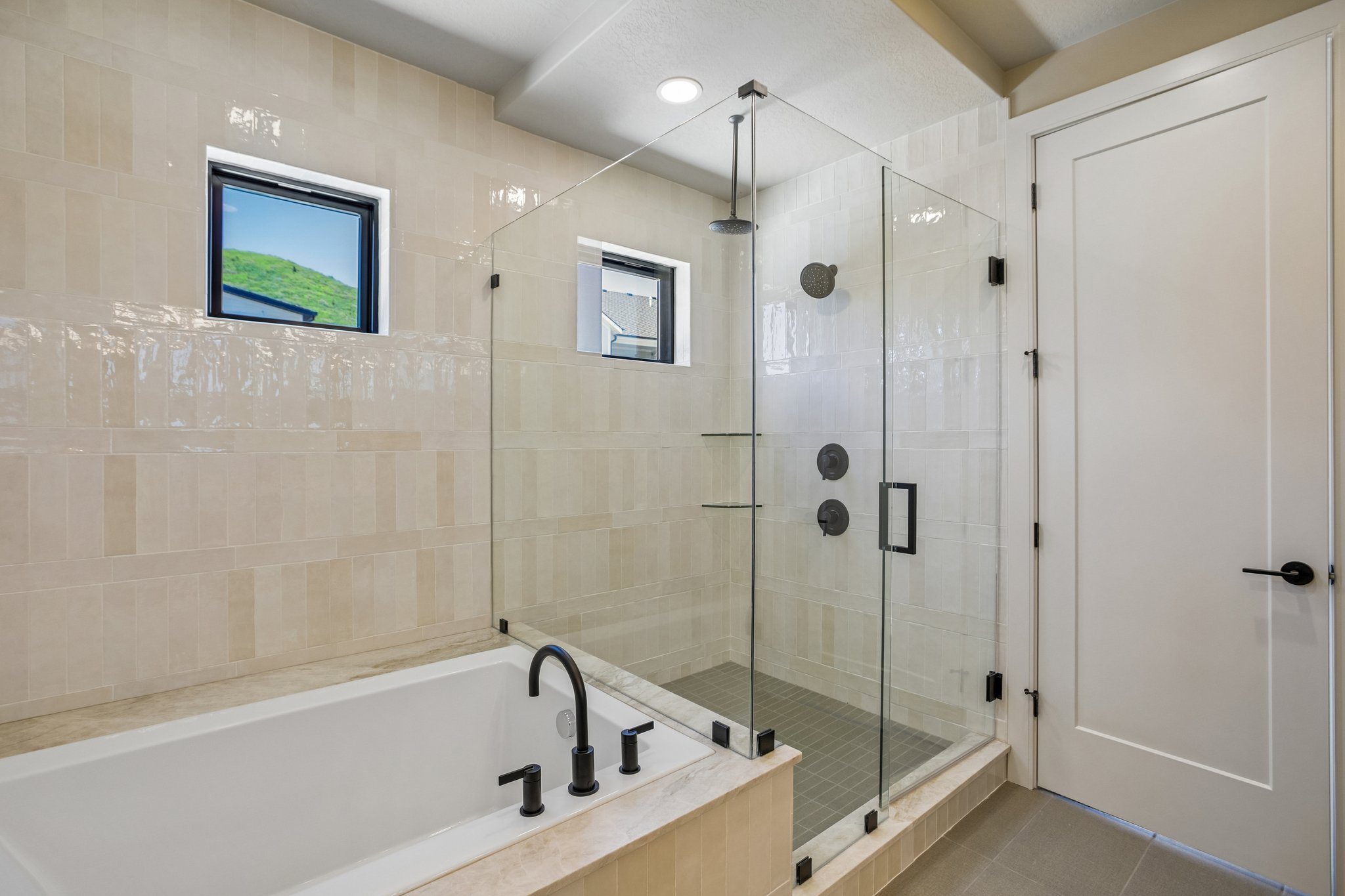 Contemporary bathroom featuring a freestanding soaking tub with matte black fixtures