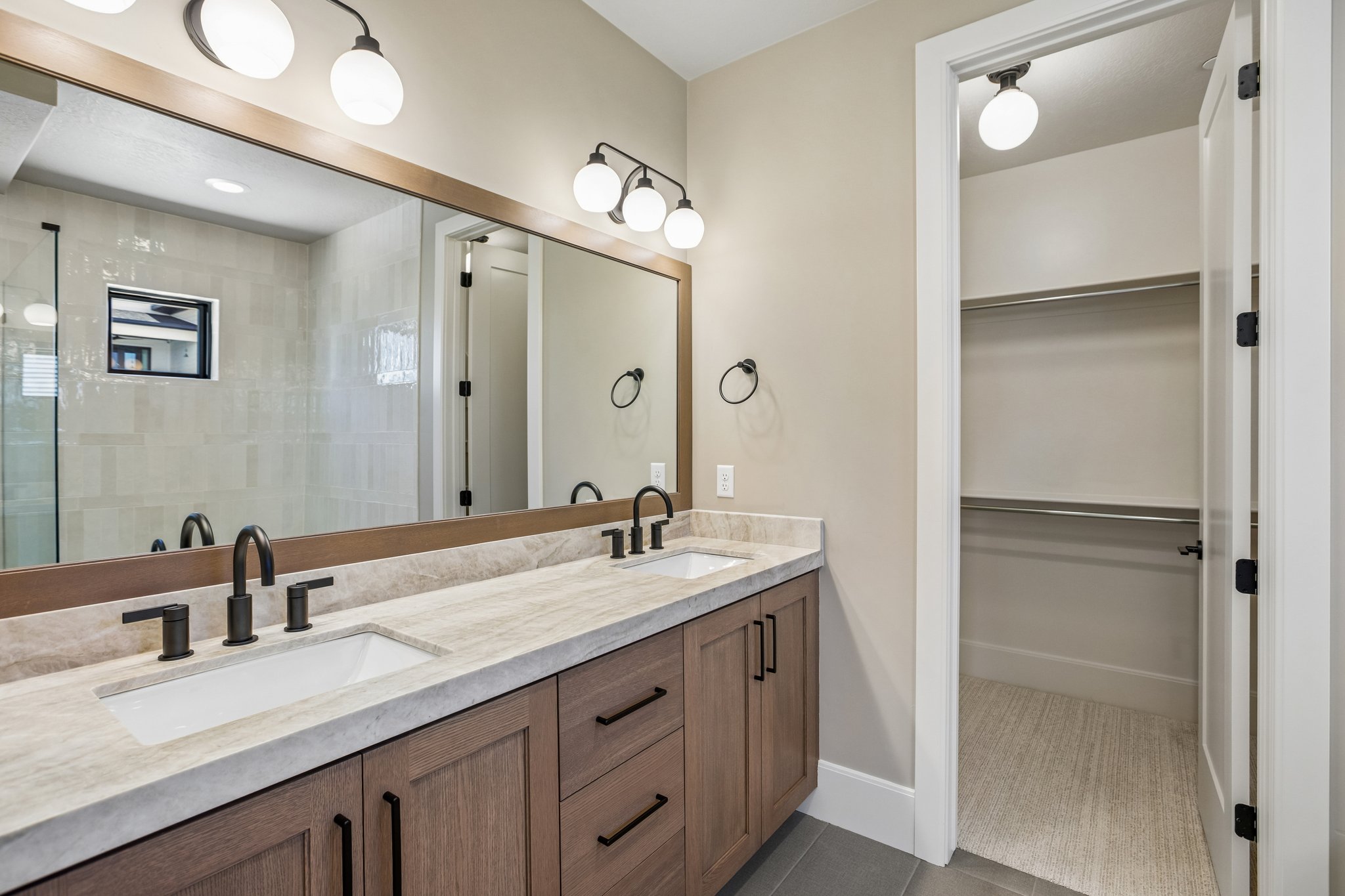 Double vanity with undermount sinks, stone countertop, and matte black fixtures