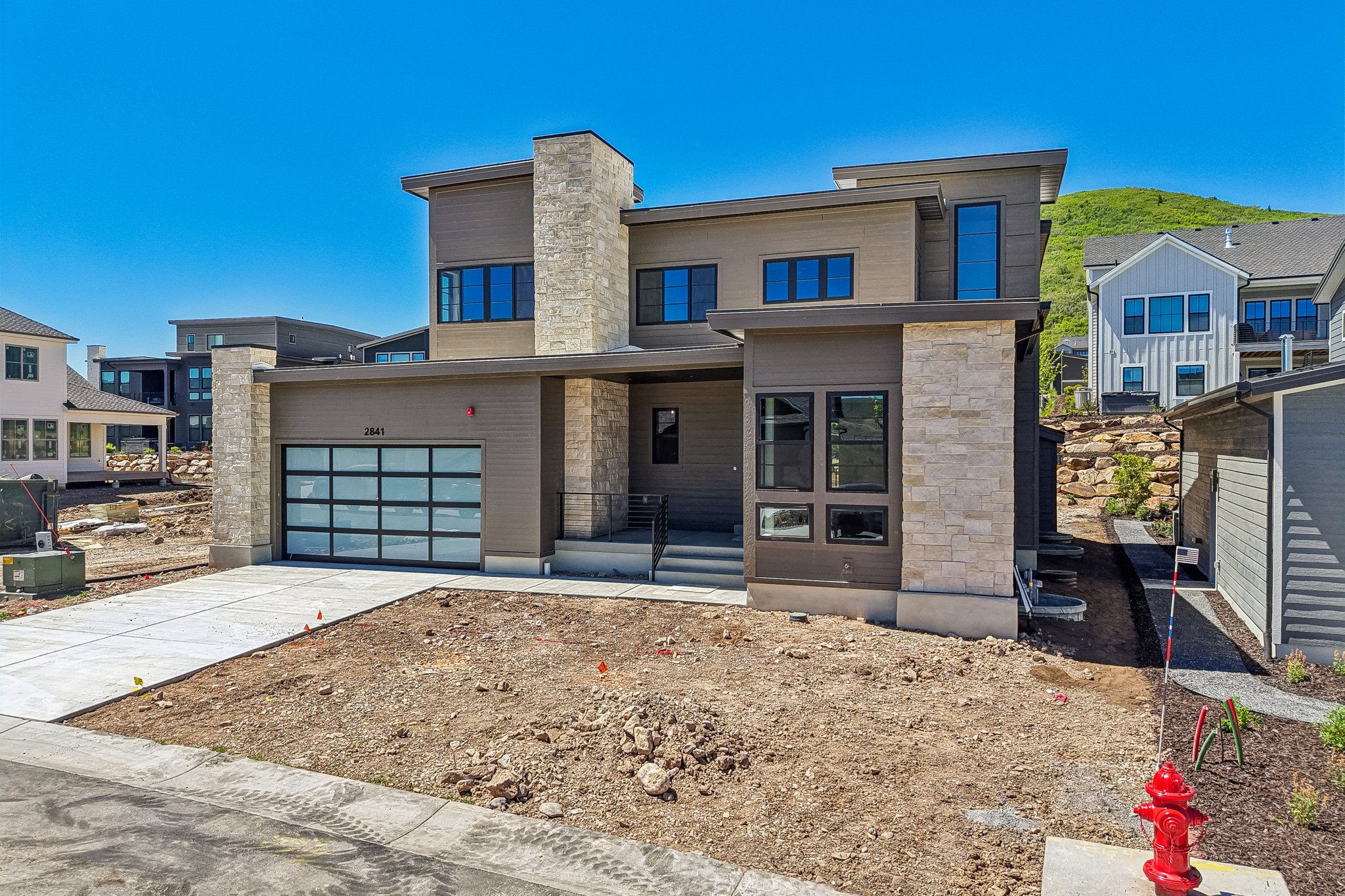 Contemporary residence featuring a multi-tone exterior with stone accents and horizontal siding