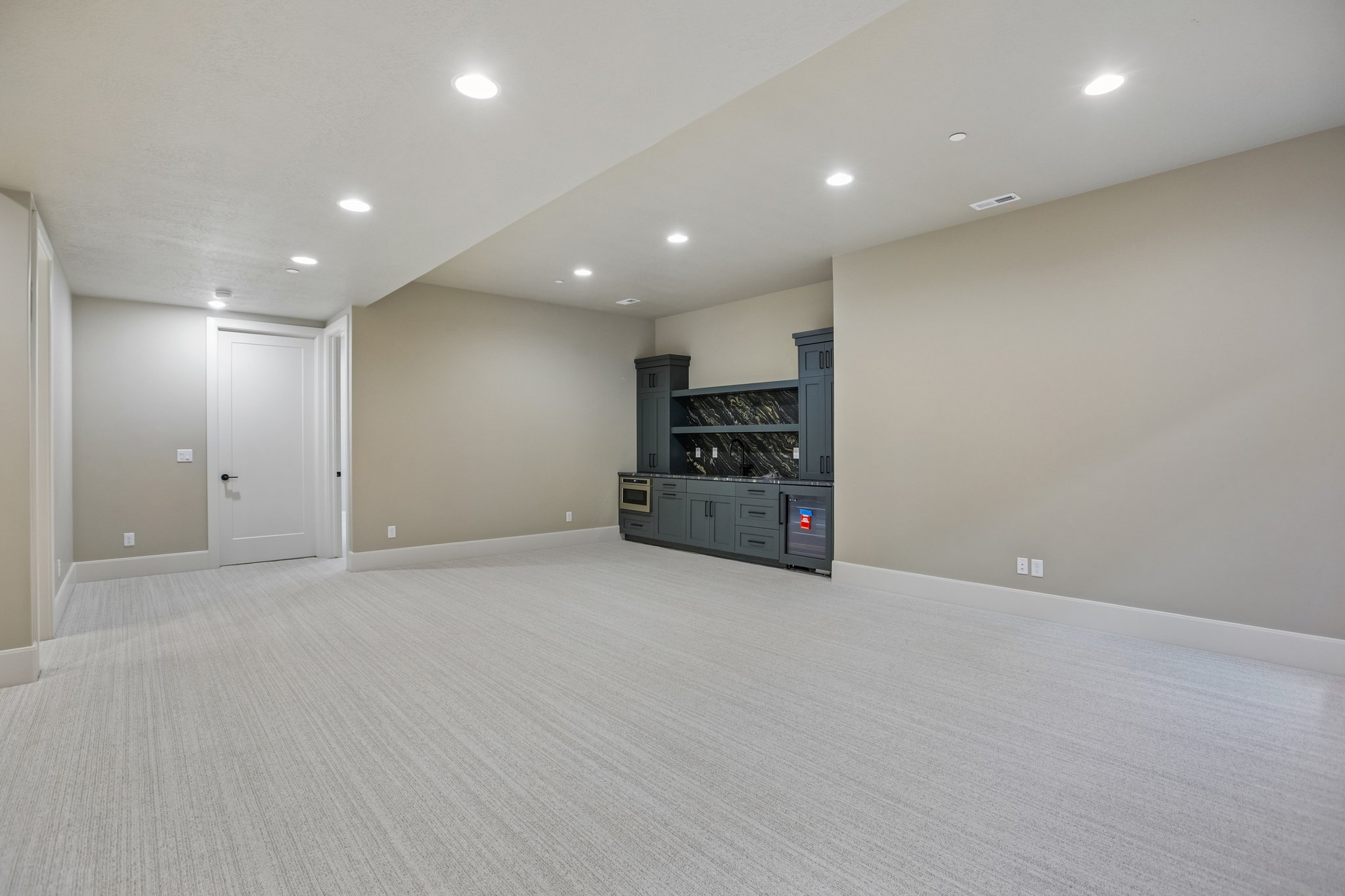 Spacious room featuring light-toned carpeting and recessed ceiling lighting