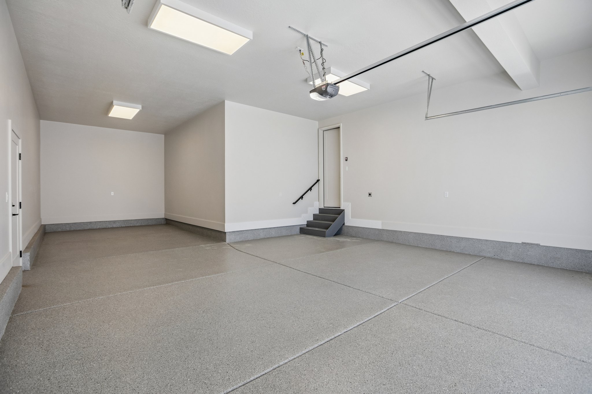 Spacious garage featuring a finished epoxy floor, recessed lighting, and direct interior access