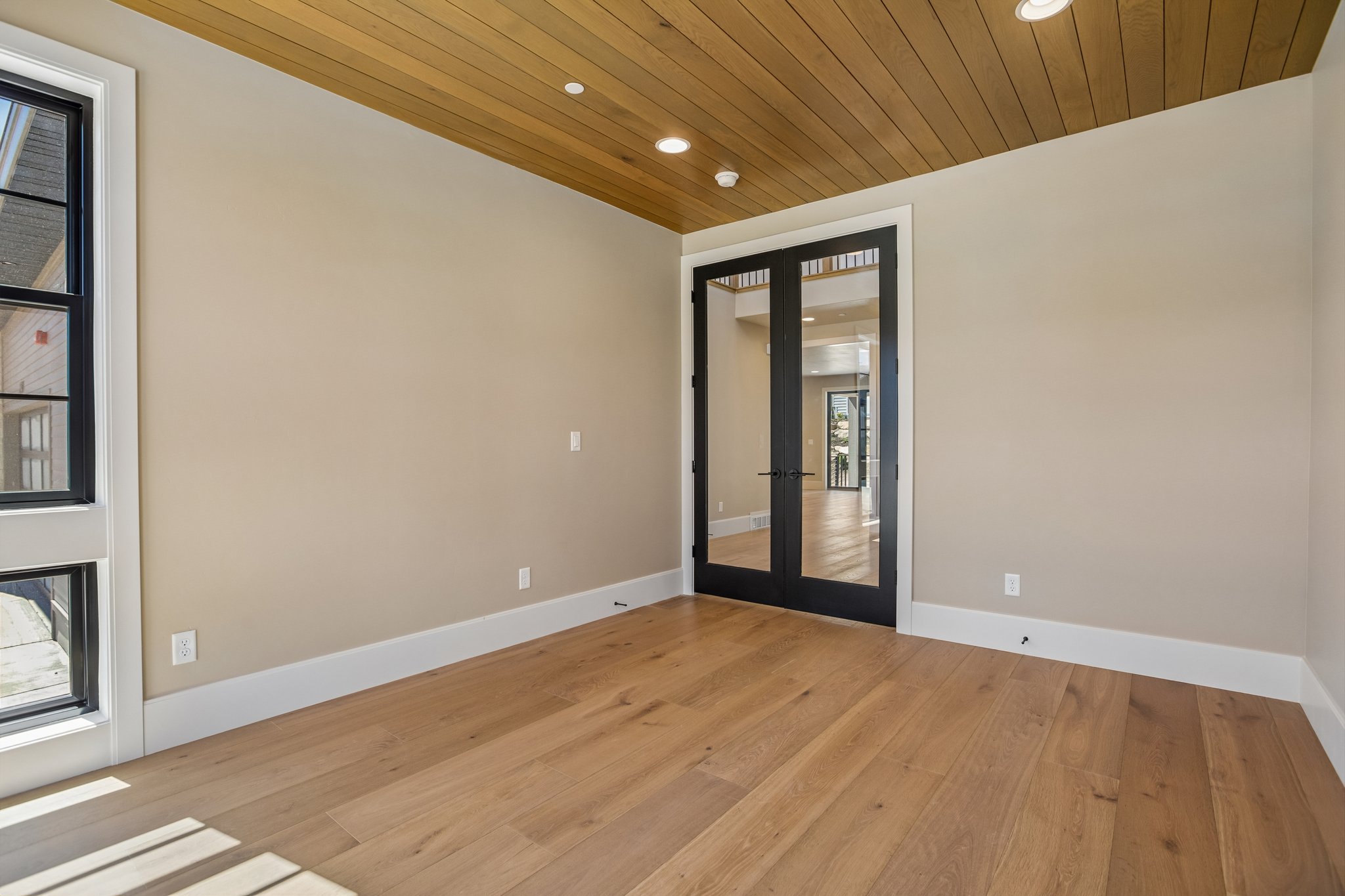 Room featuring wood-finish flooring, a wood-paneled ceiling, recessed lighting, and a double-door entry with clear glass panels