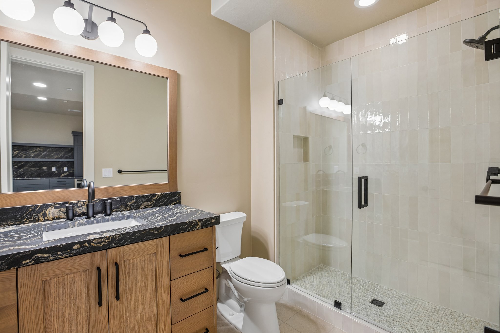 Bathroom featuring a glass-enclosed shower with tiled walls and built-in shelves