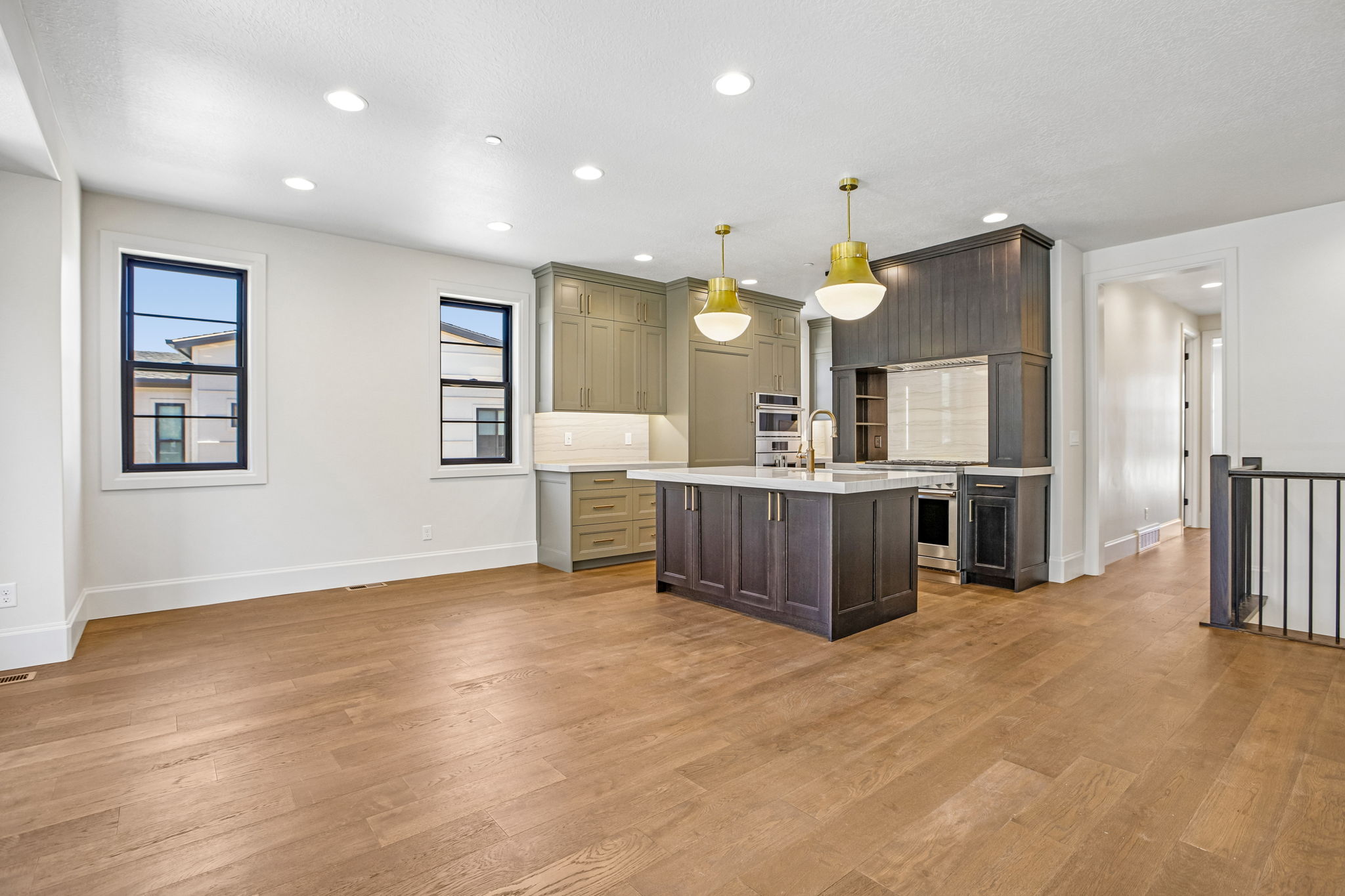 Open-concept living space featuring wood-finish flooring, recessed lighting, and modern black-framed windows