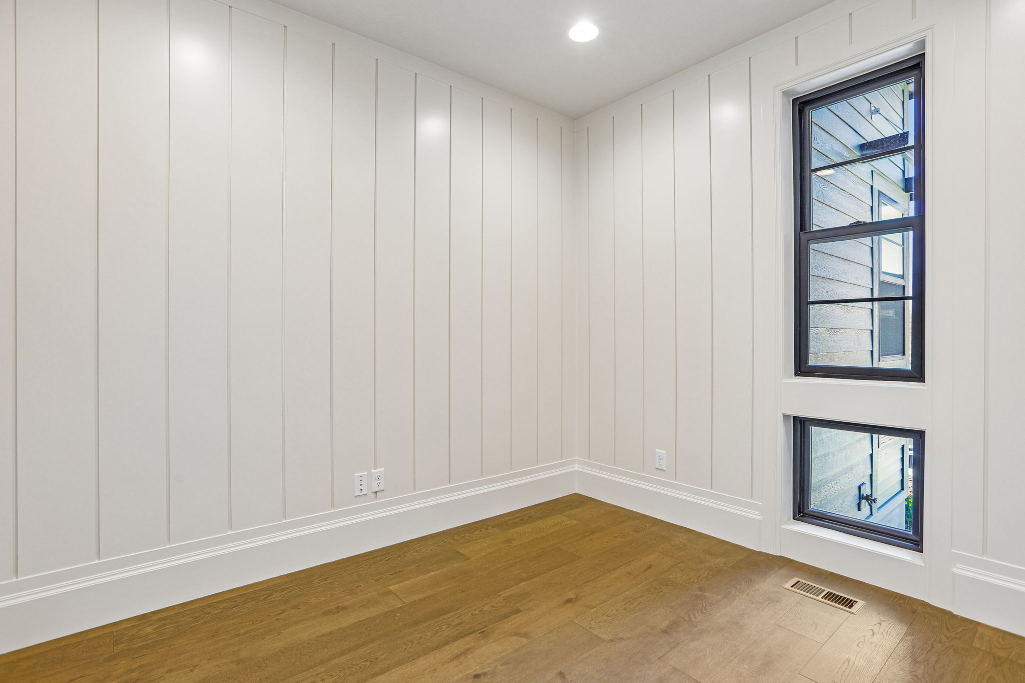 Room featuring light wood-finish flooring and white vertical paneling