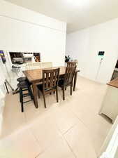 Dining area with light tile patterned flooring and baseboards