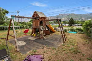 Backyard play structure featuring a wooden playset with a slide and swing components