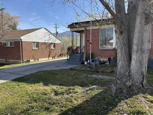 View of side of property with brick siding and a yard