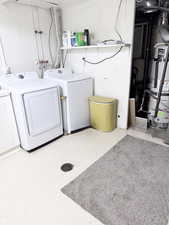 Laundry area featuring gas water heater, washer and clothes dryer, and light flooring