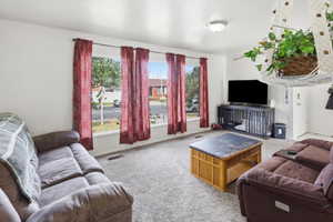 Light-filled living space featuring a picture window, recessed ceiling light, and wall-to-wall carpeting