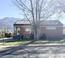 View of front of home featuring brick siding, a mountain view, and a front yard