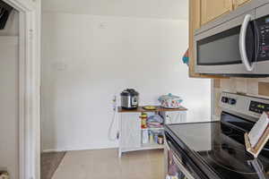 Kitchen area featuring stainless steel appliances, including an electric range and an over-the-range microwave