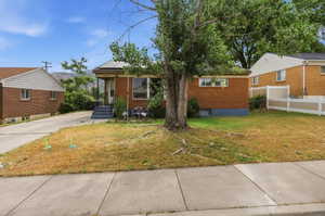 Brick exterior residence with a concrete driveway and front sidewalk