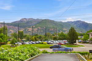 Mountain backdrop with vibrant green foliage and a large parking area