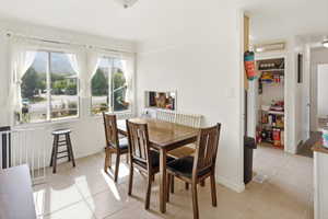Dining area featuring tile flooring, a large window unit, and a built-in pantry with shelving