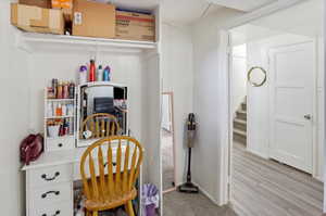 White paneled walls feature a built-in closet with an upper storage shelf