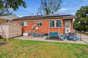 Red brick exterior featuring multiple windows and a covered entry