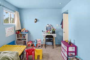 Carpeted interior room featuring a single window and light blue walls